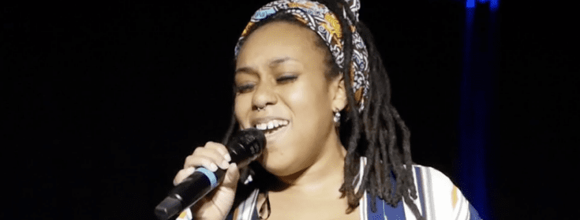 Singer performing passionately on stage with microphone.